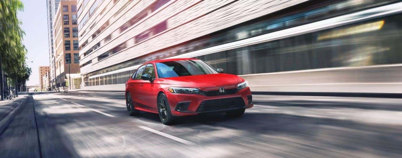 Red 2023 Honda Civic driving to a used Honda dealer near Morristown
