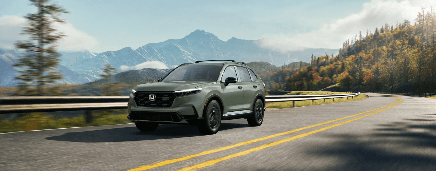 Green 2026 Honda CR-V driving in front of mountains