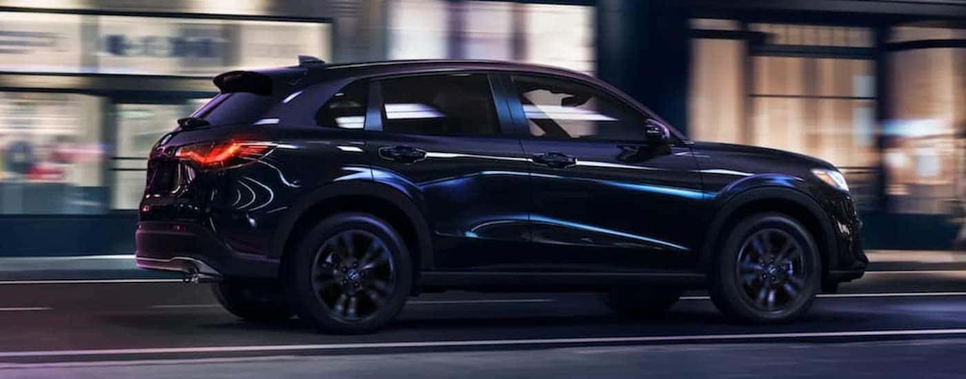 A black 2026 Honda HR-V driving down a city street at night