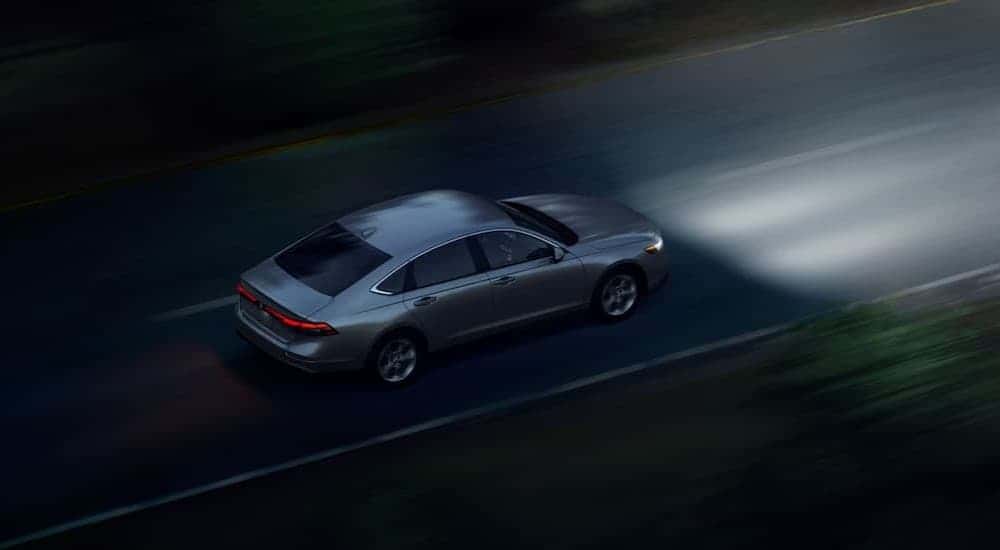 A silver 2026 Honda Accord driving at night.