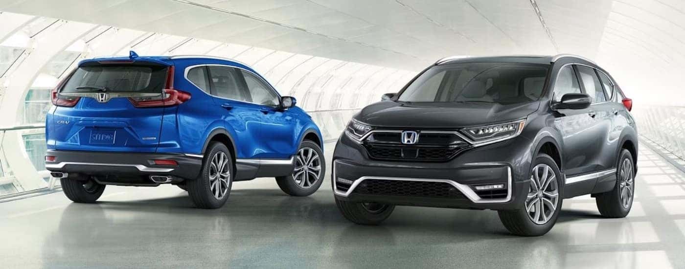 Blue & black 2021 Honda CR-V Touring and Hybrid side-by-side.