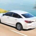 White 2022 Honda Civic LX driving along the water