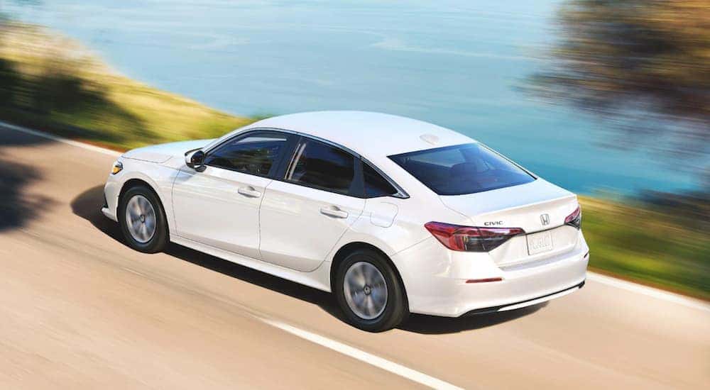 White 2022 Honda Civic LX driving along the water