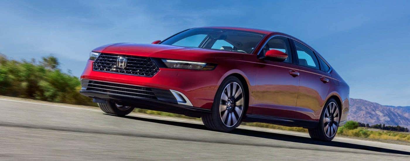Red 2023 Honda Accord driving on a road