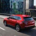 Red 2023 Honda CR-V driving through the city
