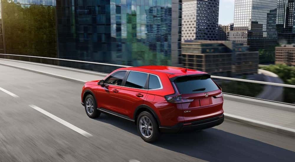 Red 2023 Honda CR-V driving through the city