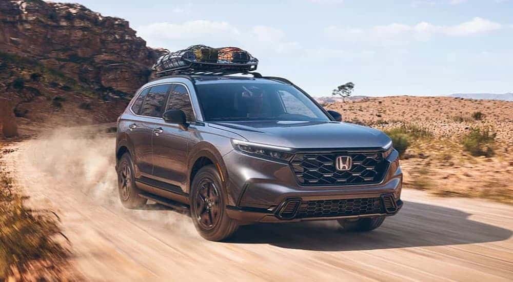 Grey 2023 Honda CR-V Sport on a trail with luggage on the racks