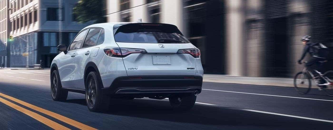 White 2023 Honda HR-V Sport driving through a city