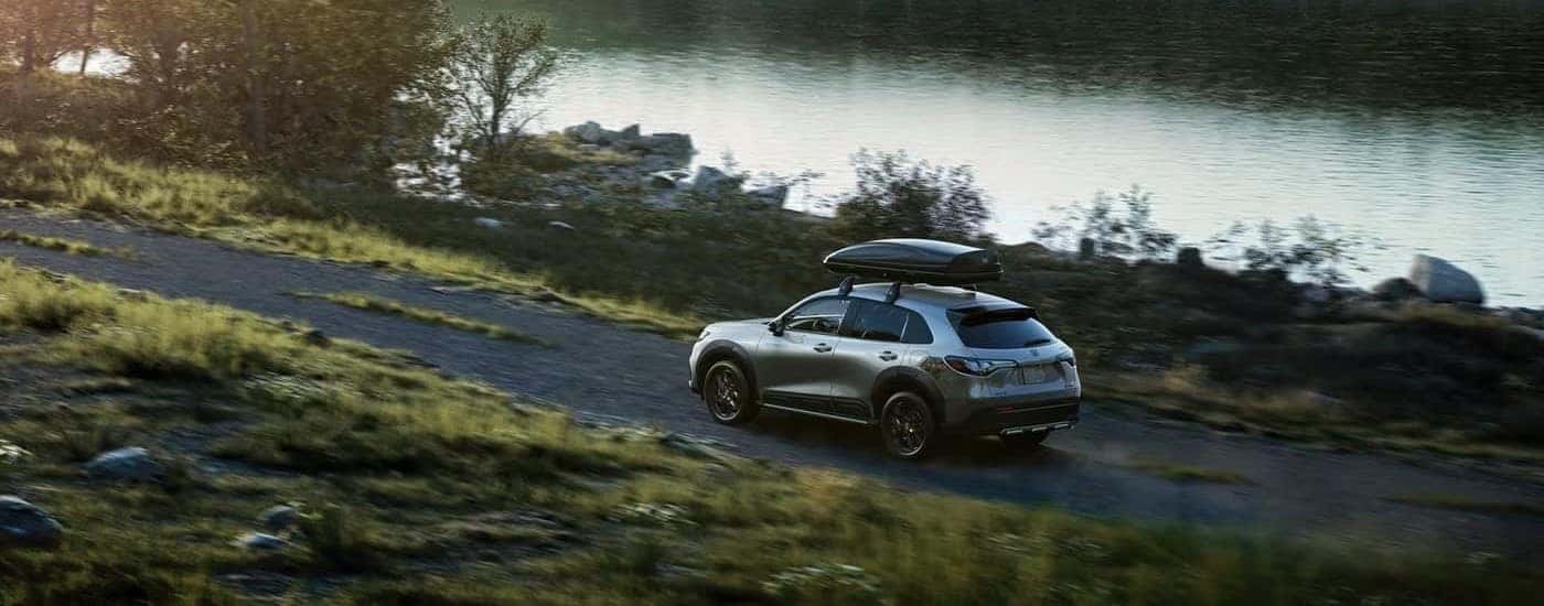 Grey 2026 Honda HR-V driving past a lake