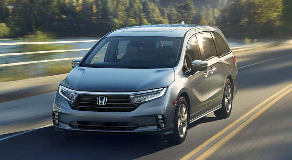 Grey 2023 Honda Odyssey Elite driving down the road