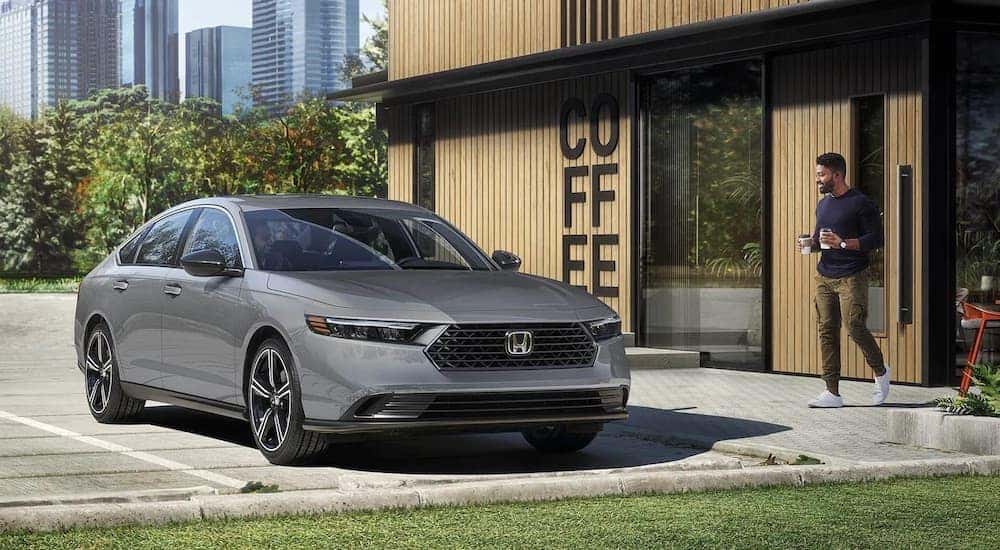 A gray 2026 Honda Accord Hybrid parked near a coffee shop.
