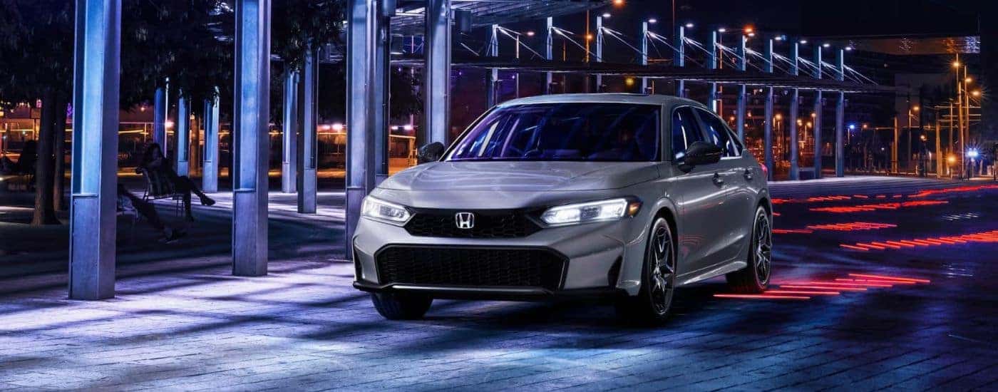 Silver 2026 Honda Civic Hybrid Sport driving at night