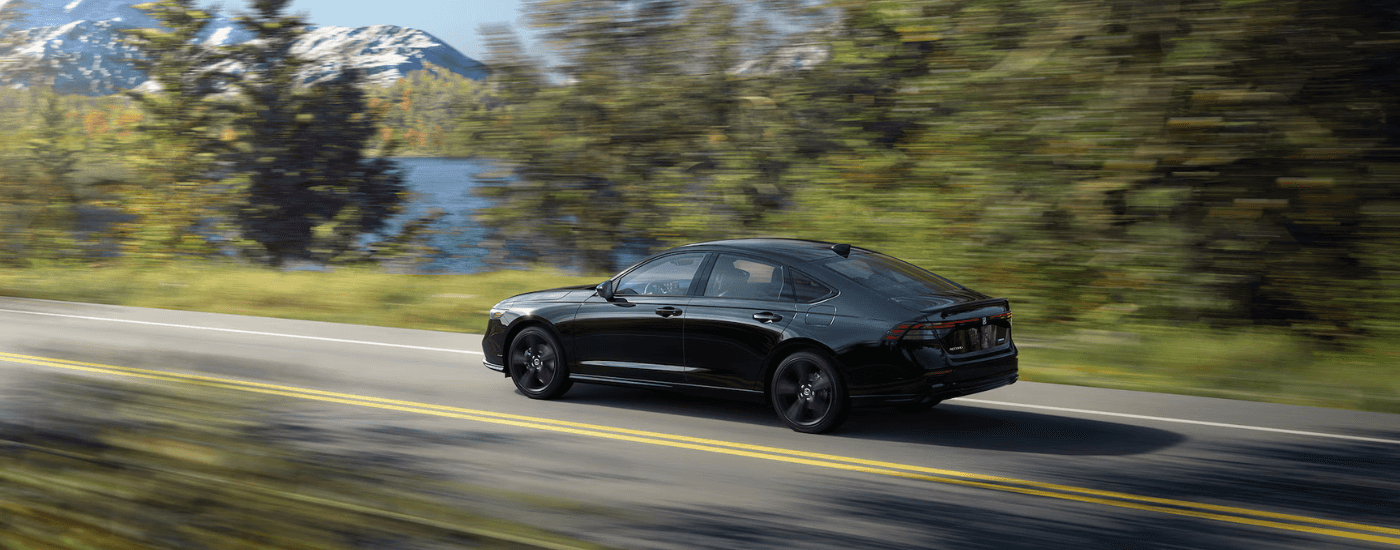 Black 2026 Honda Accord Hybrid driving past water