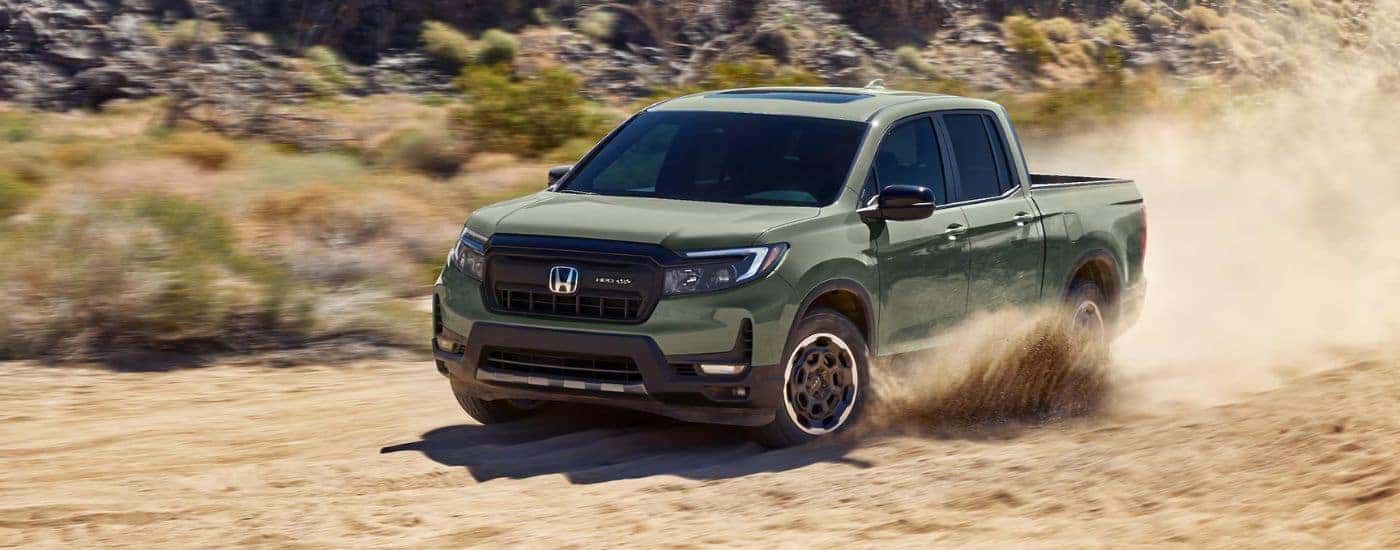 Green 2026 Honda Ridgeline TrailSport driving through sand in a desert