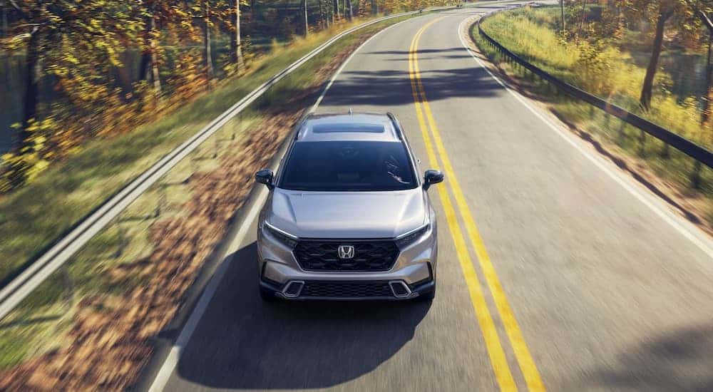 Grey 2026 Honda CR-V driving on a winding road