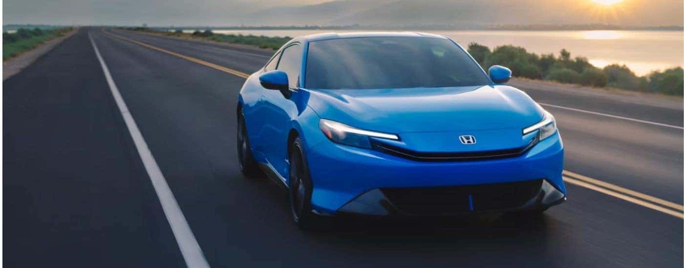 Blue 2026 Honda Prelude driving at sunset.