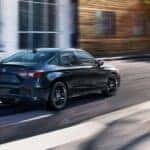 A black 2026 Honda Civic Hybrid driving in a city.
