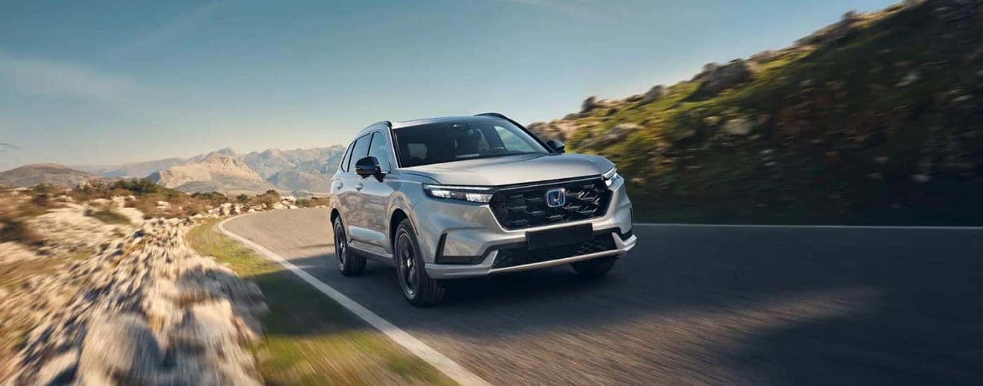White 2025 Honda CR-V hybrid driving.