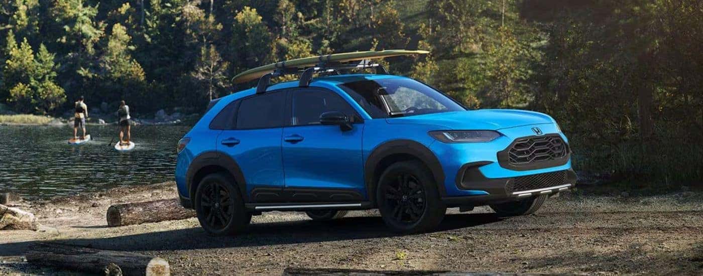Blue 2026 Honda HR-V Sport parked near a lake with Paddleboarders in the background
