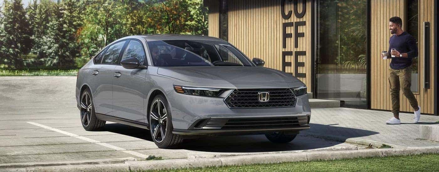 Grey 2026 Honda Accord Hybrid parked outside a coffee shop.