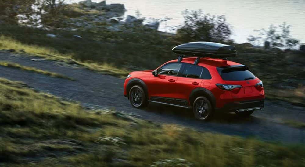 Red 2027 Honda HR-V Sport driving on a dirt road