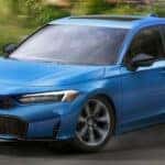 A blue 2026 Honda Civic Hatchback turning a corner on the road.