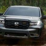 A gray 2026 Honda Ridgeline TrailSport shown driving in mud.