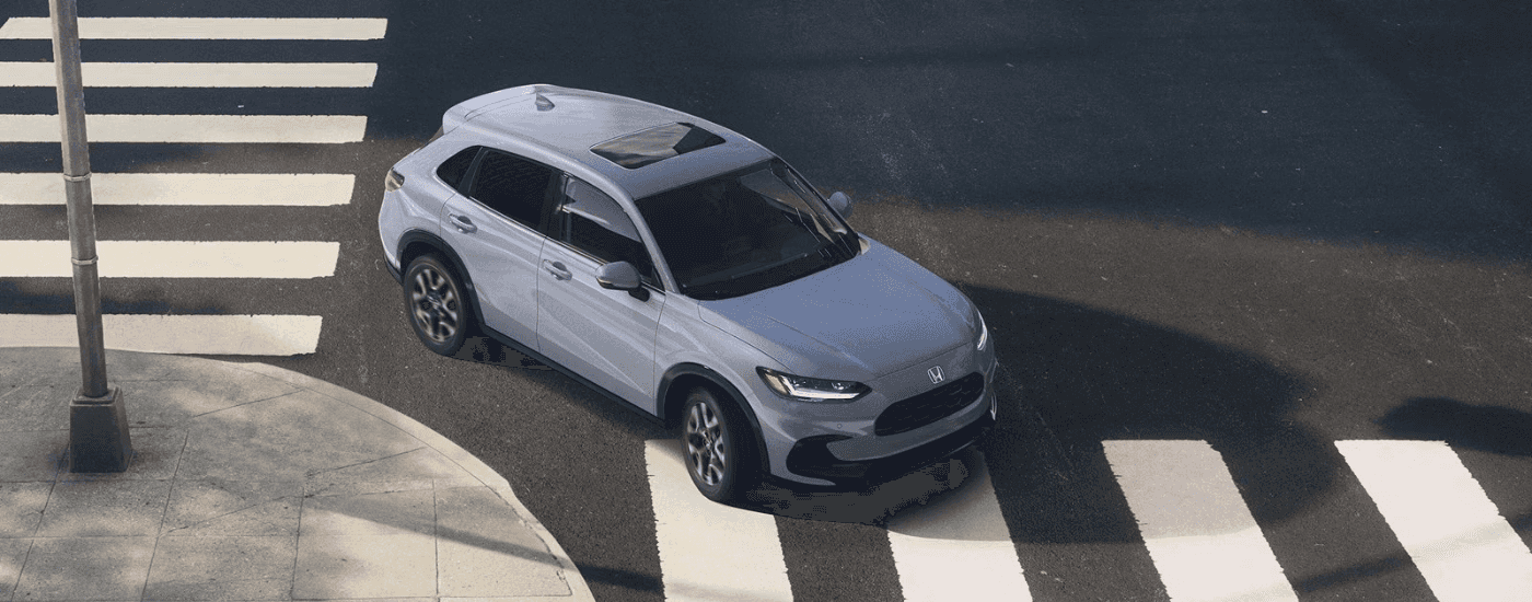 Gray 2026 HR-V turning a corner over a crosswalk.