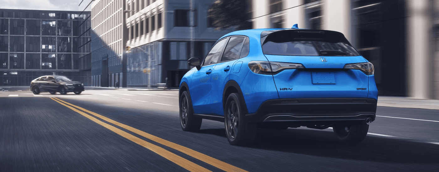 Rear of a blue 2026 HR-V driving down a road.