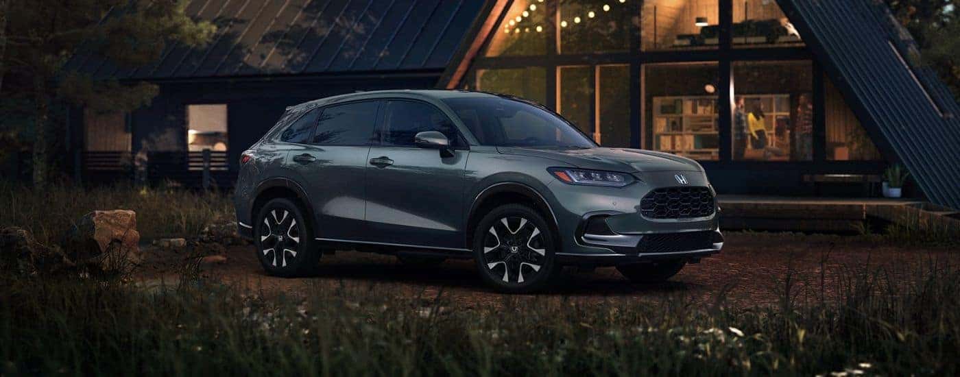 Side view of a forest green 2027 Honda HR-V parked outside a house.