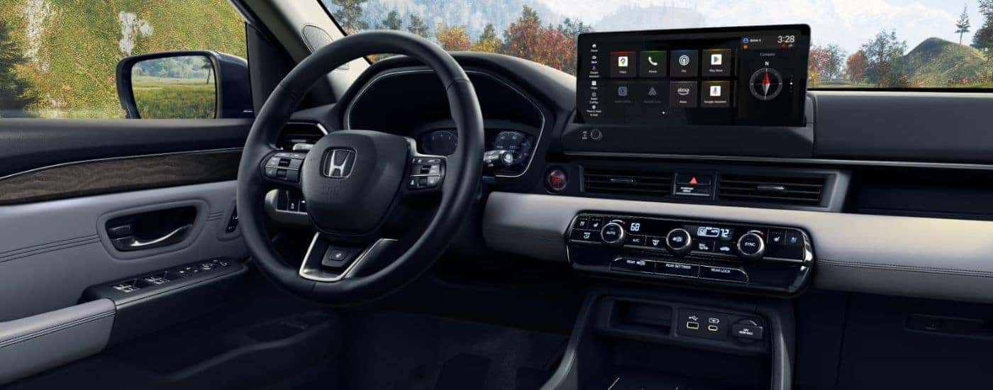 Interior view of a 2026 Honda Pilot infotainment display and steering wheel.