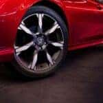 Close up of tires on a red 2026 Honda Civic Sport Touring Hybrid at night.