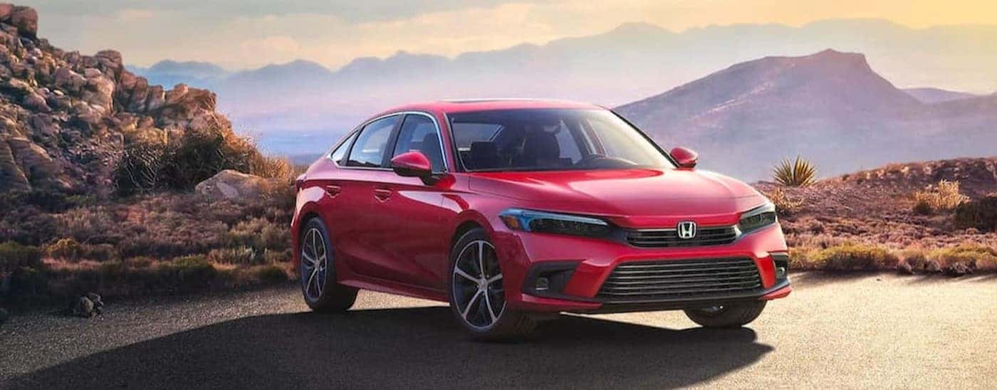 A red 2023 Honda Civic parked near mountains.