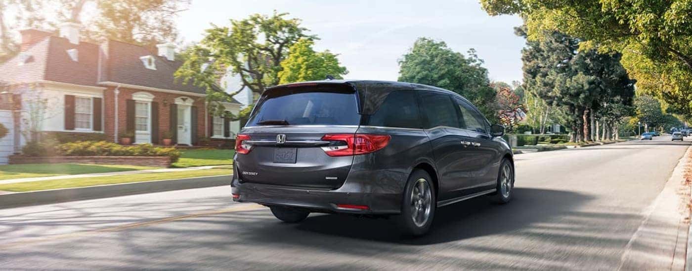 A rear gray 2022 Honda Odyssey driving in suburbs.