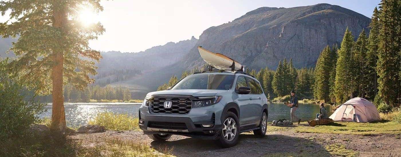 A silver 2023 Honda Passport TrailSport parked by a lake.