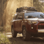A red 2017 Toyota 4Runner driving through the woods.
