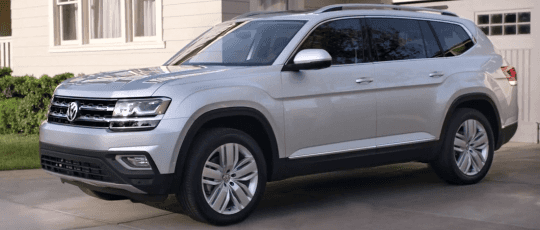 The 2018 Volkswagen Atlas parked in front of a house.