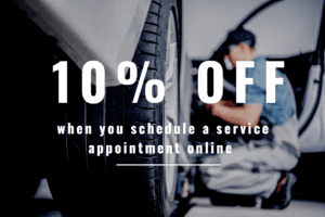 10% off when you schedule a service appointment online is what it says over a photograph of a technician at wheel level of a vehicle. 