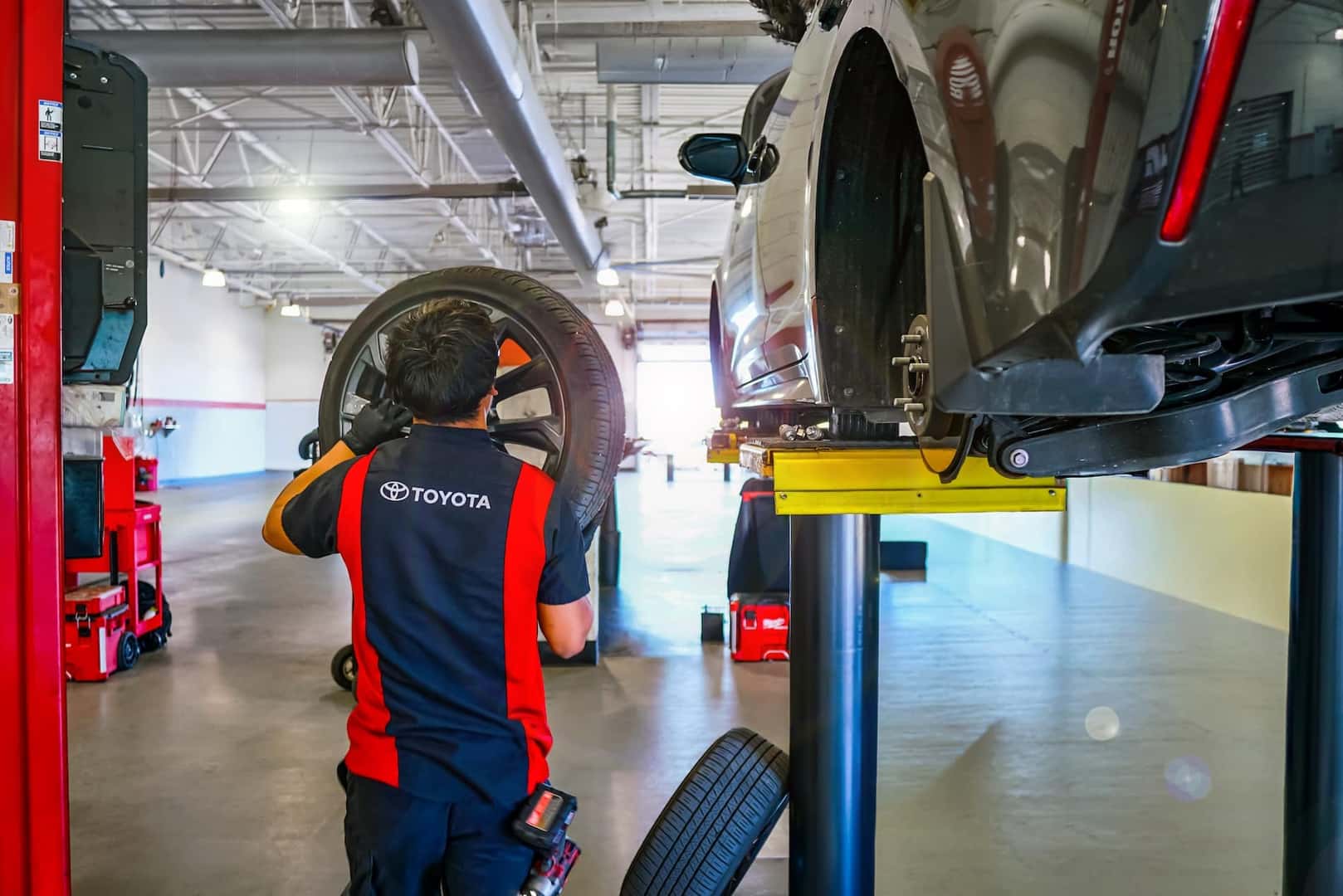 technician replacing tire on vehicle
