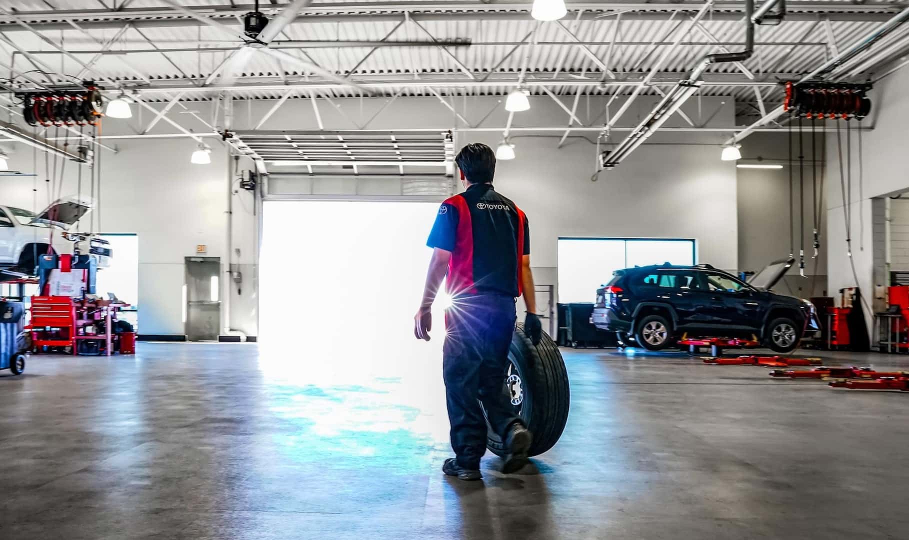 technician holding tire in service garage