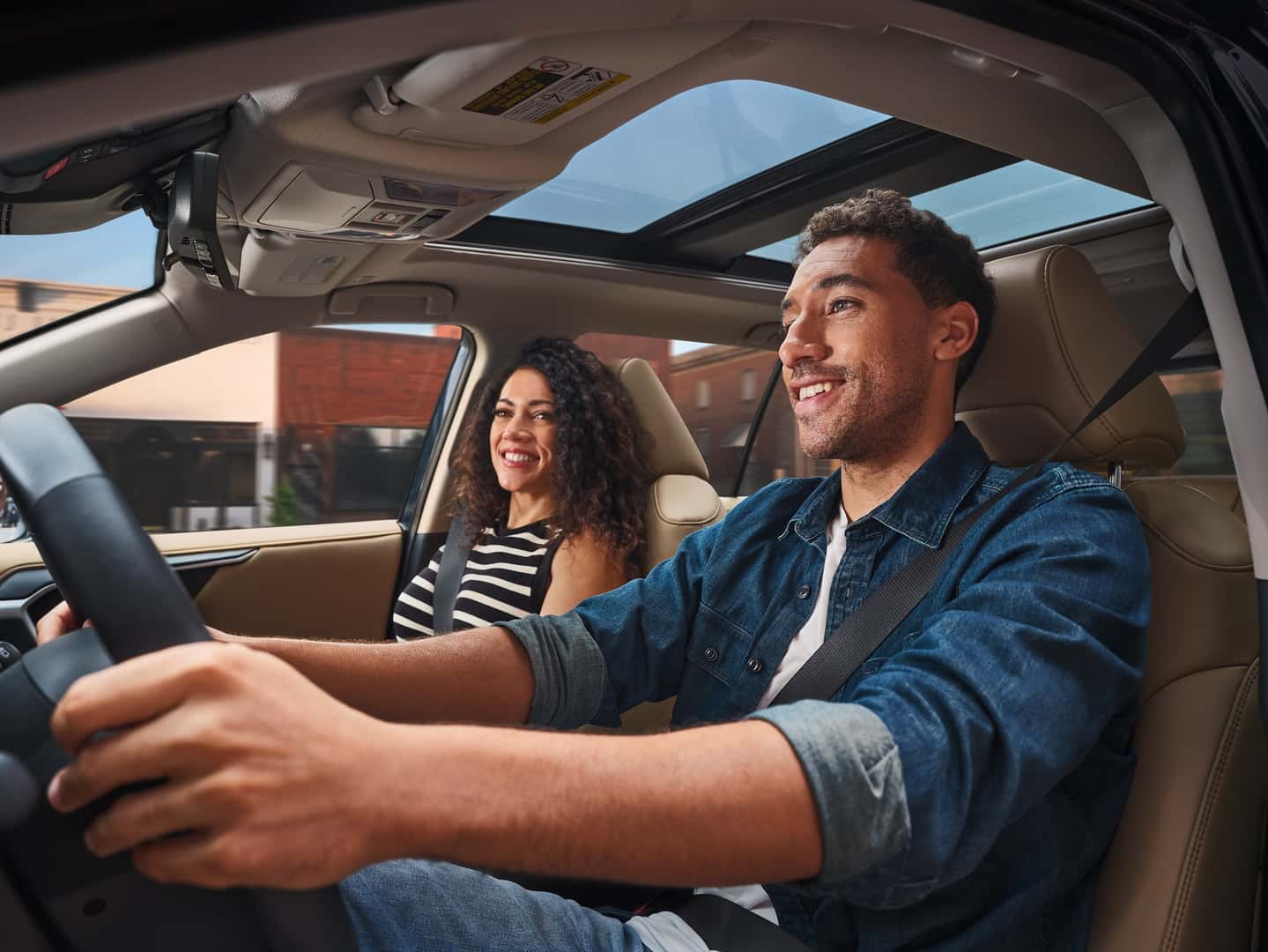 Man and woman driving in a Toyota