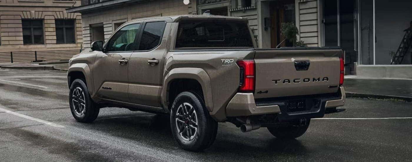 A brown 2026 Toyota Tacoma driving in a city.