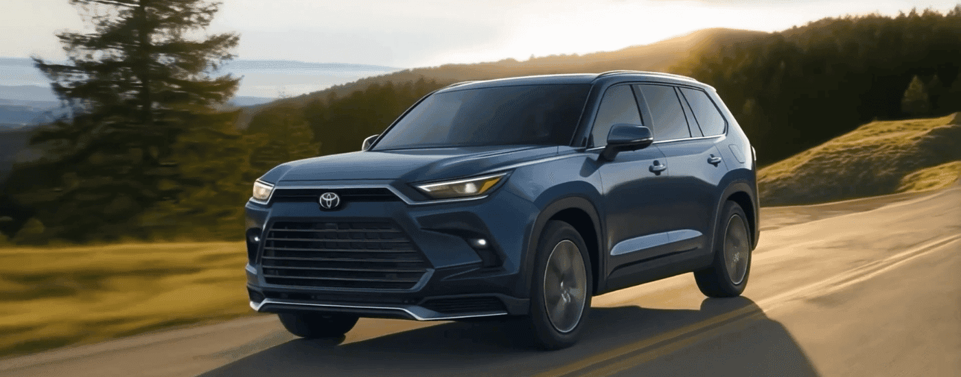 Blue 2026 Toyota Grand Highlander driving on an open road