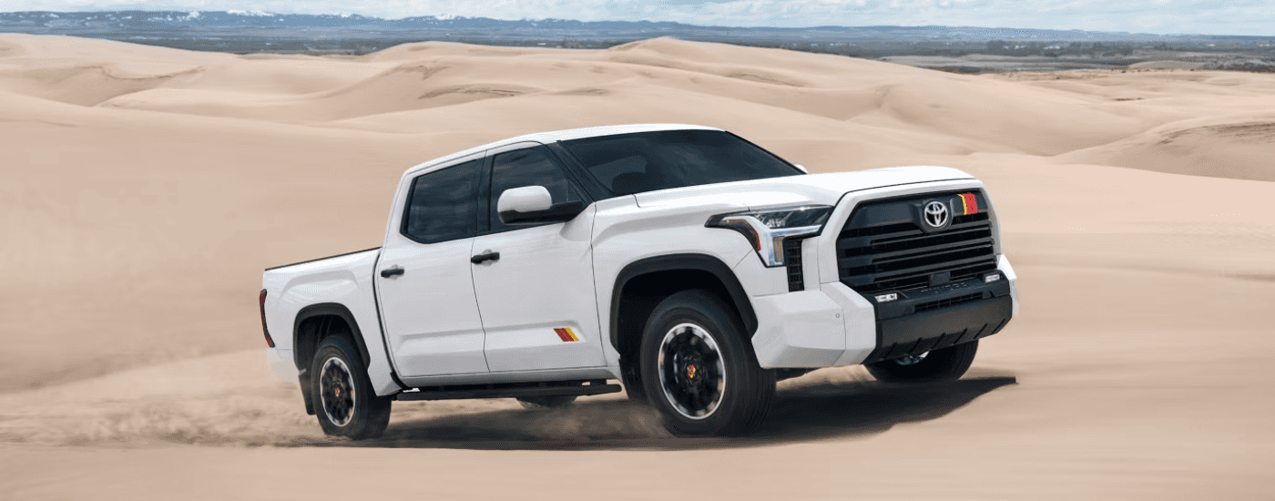 White 2026 Toyota Tundra driving through sand dunes