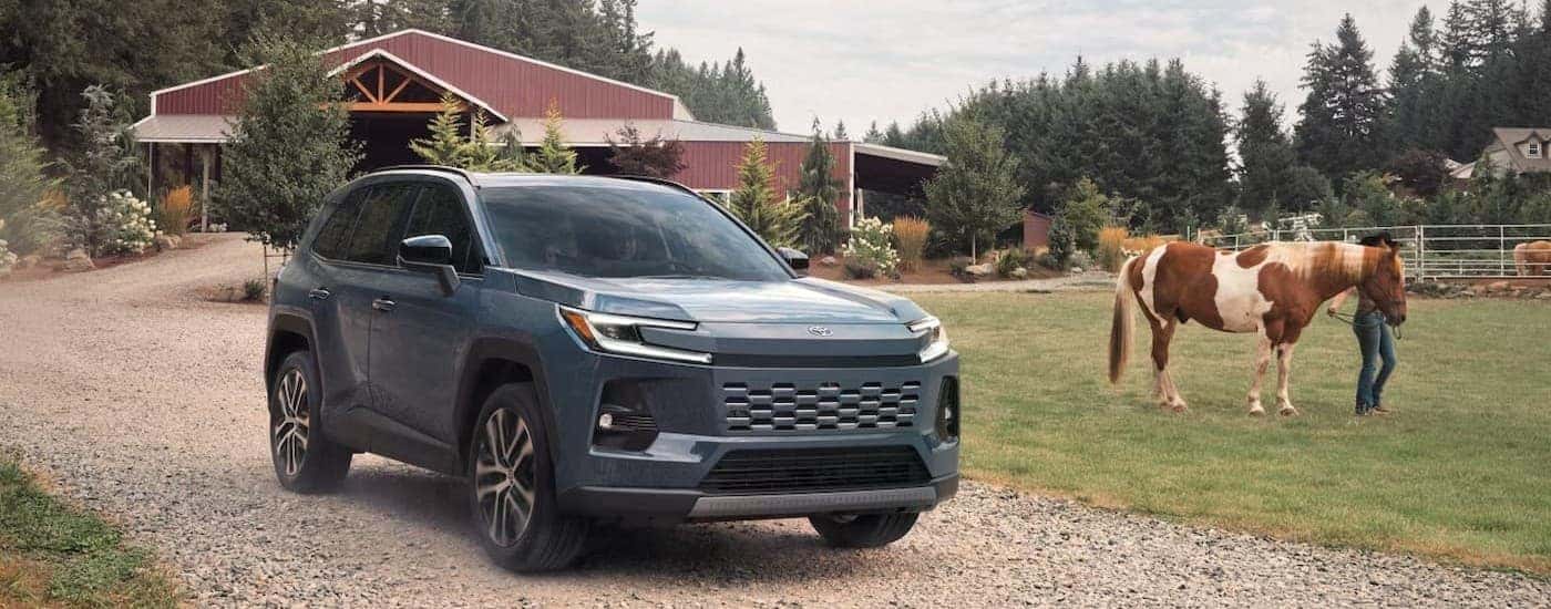 A blue 2026 Toyota RAV4 on a farm.