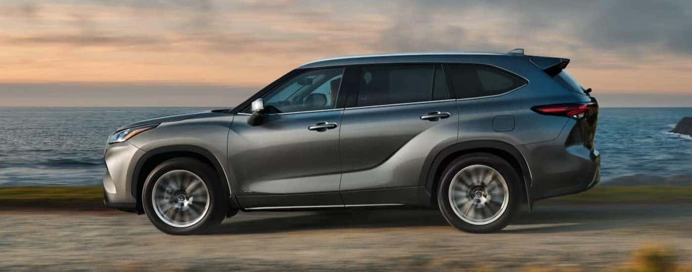 A silver 2025 Toyota Highlander driving near water.