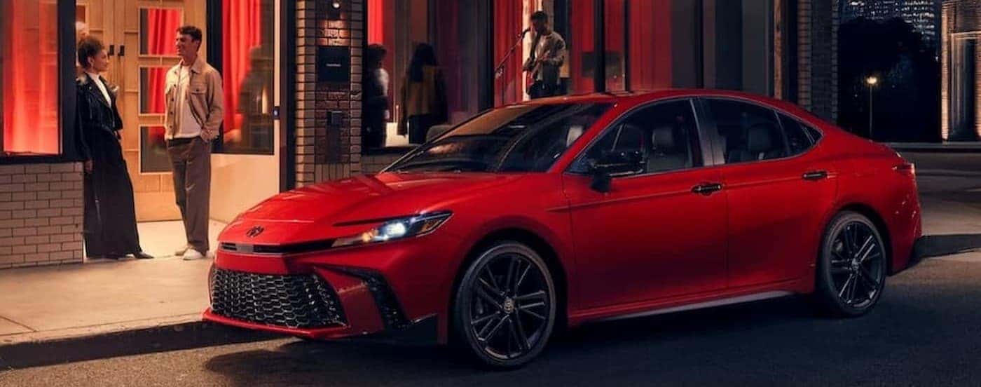 A red 2026 Toyota Camry parked in a city.