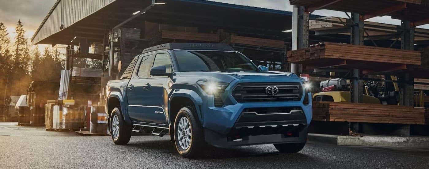 A blue 2026 Toyota Tacoma parked in a lumberyard.