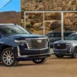 Two 2021 Cadillac Escalades parked outside building
