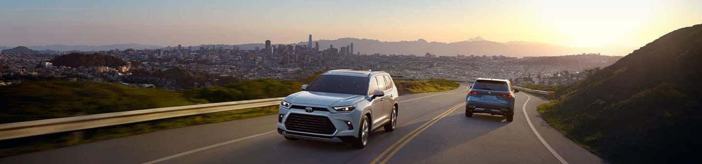 Toyota vehicles on suburban streat in the mountains with large city